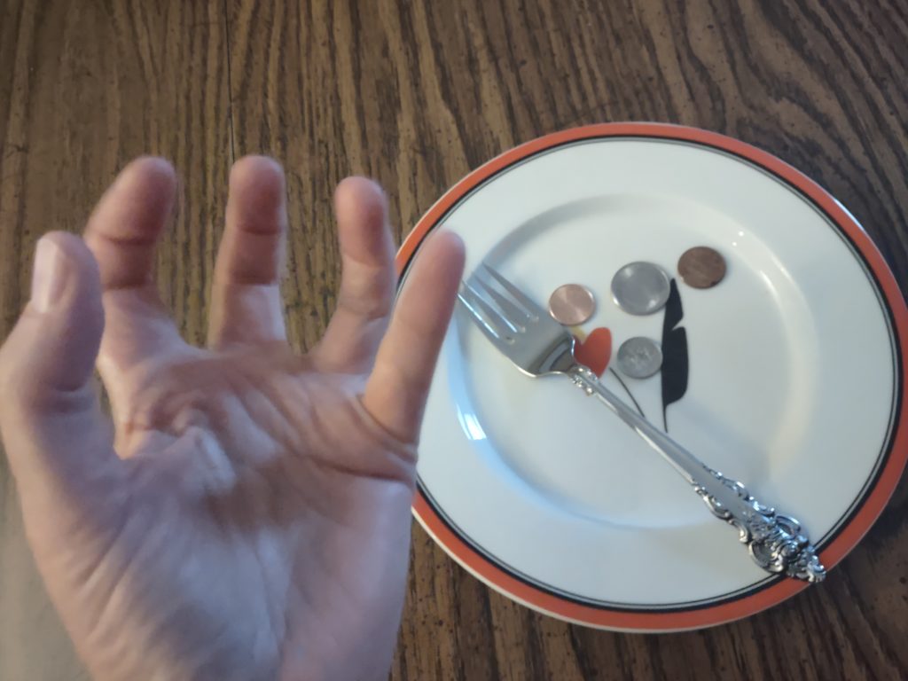 A plate containing pennies and small change crossed with a fork and an upturned hand.